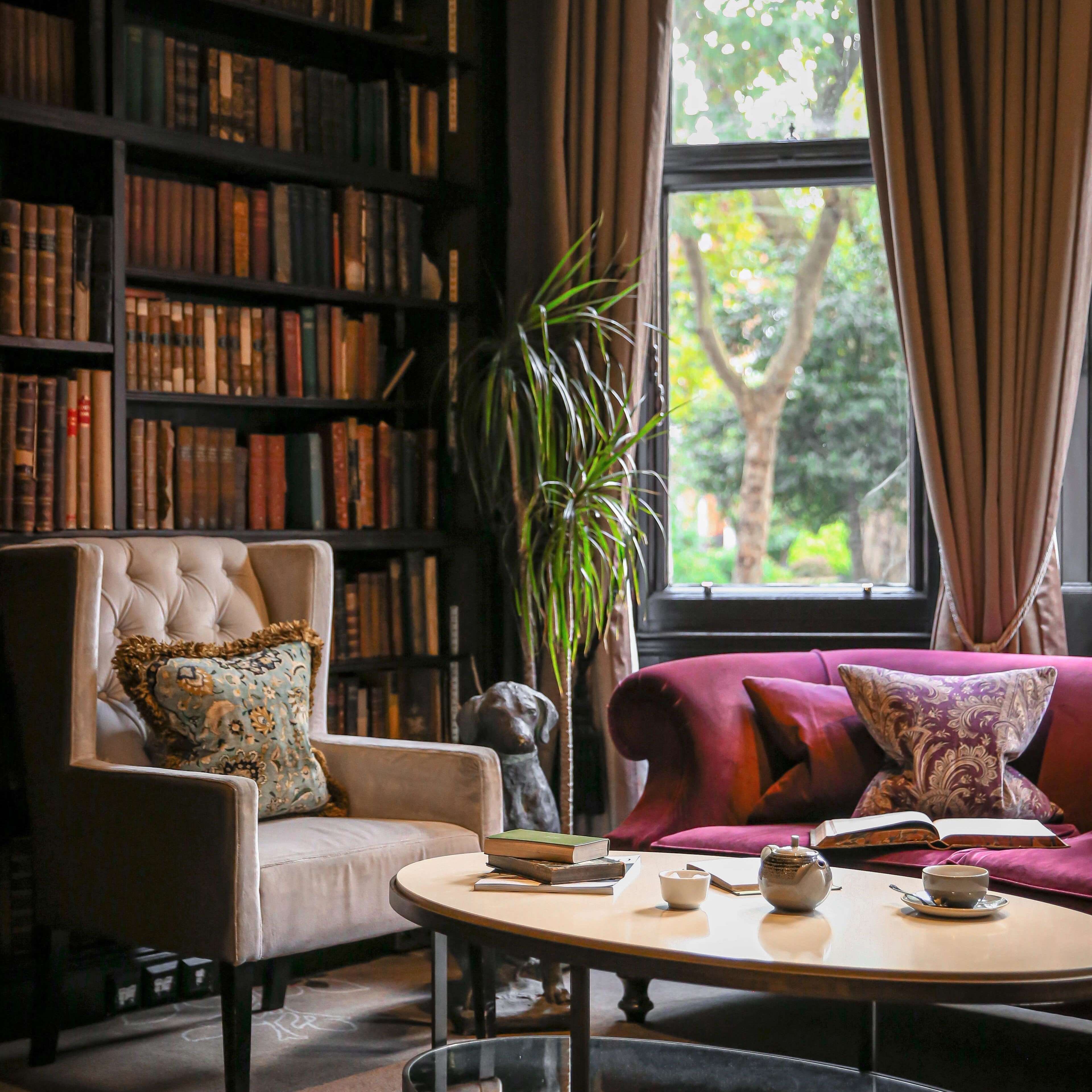 Cozy library at 11 Cadogan Gardens with furniture, bookshelves and scenic window view