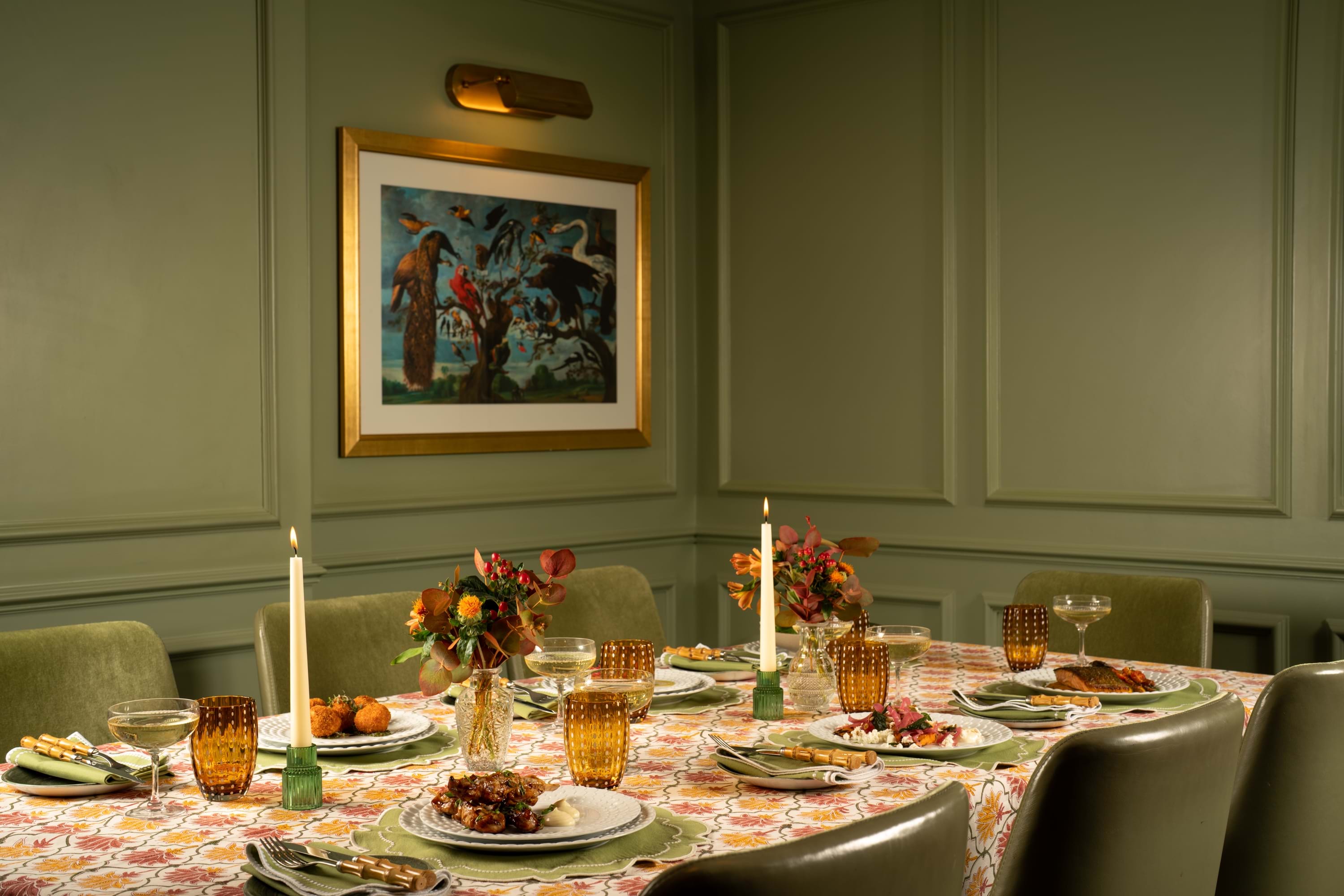 Private dining room at 11 Cadogan Gardens with floral table setting, candles and framed bird artwork